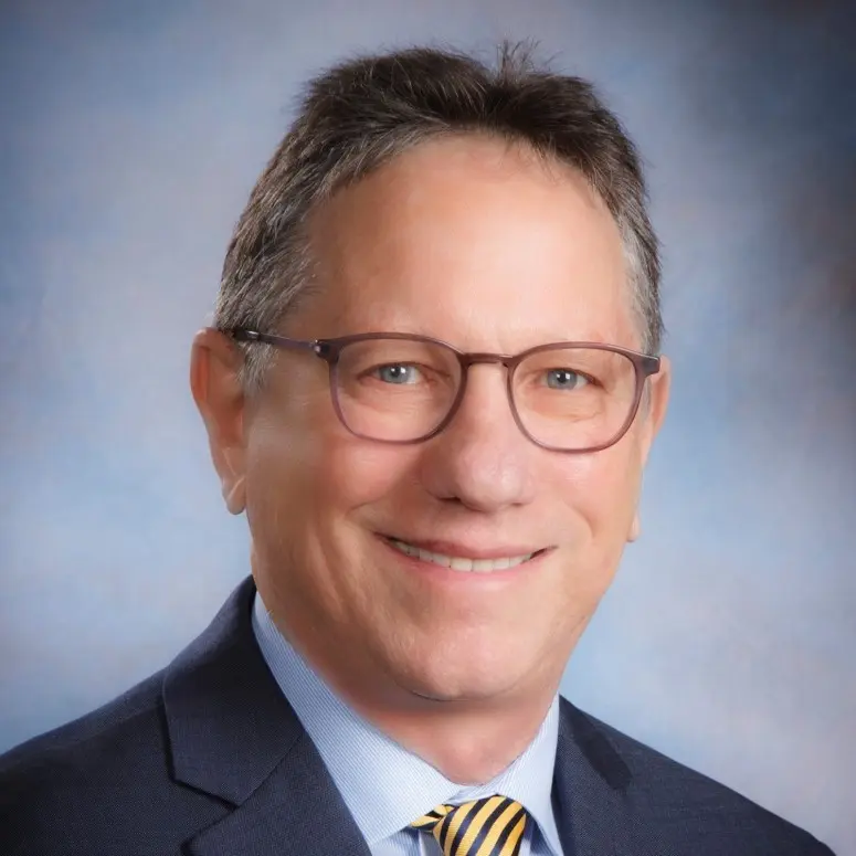 Closeup headshot of David in a blue suit