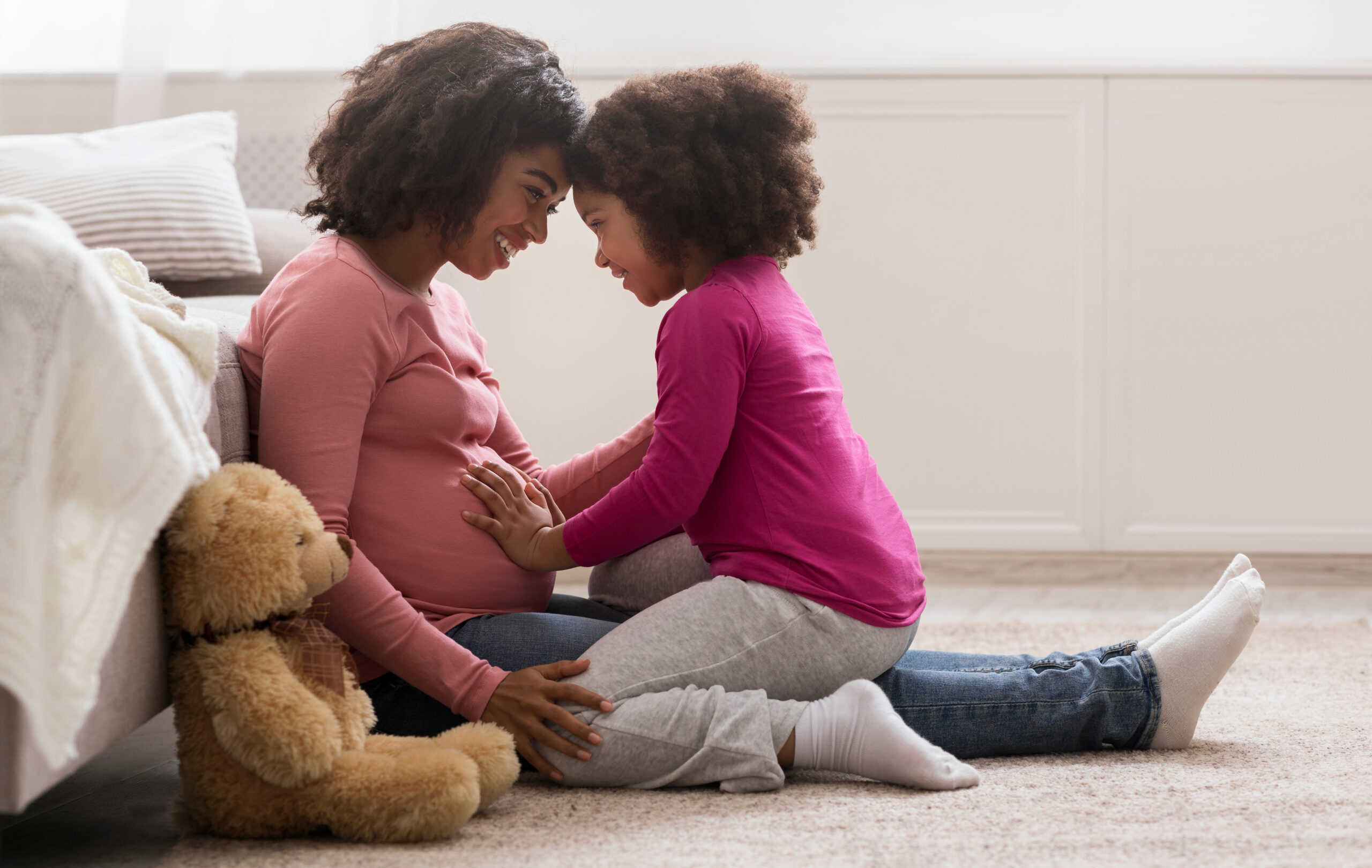 Side View Portrait Of Happy Pregnant Black Woman And Her Little Daughter