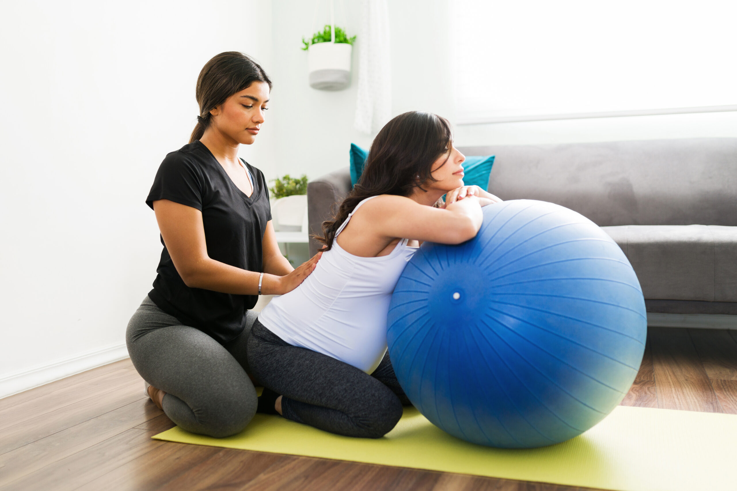 Doula massaging back of pregnant woman